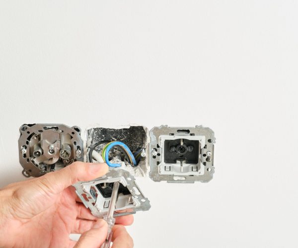 man hands with screwdriver repairing sockets at home